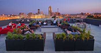 a roof top lounge with a city skyline in the background at Vue Apartments, Des Moines, IA 50309